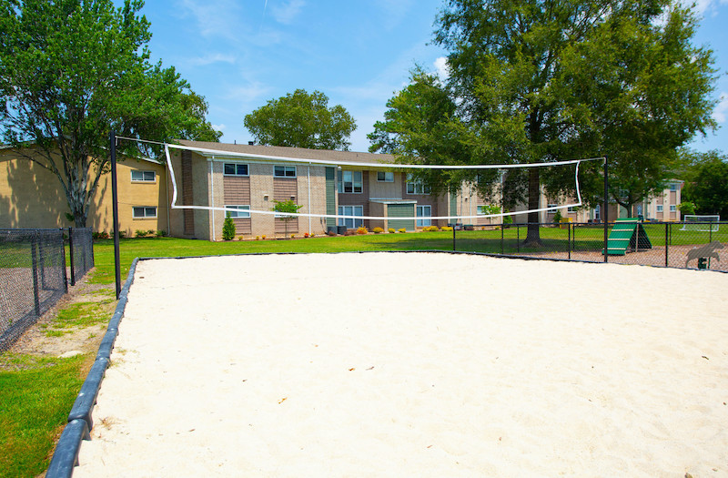 Volleyball or other sandy game court with apartments in background