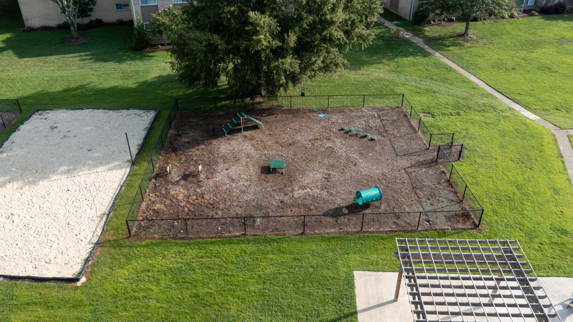 Aerial view of dog park, a pergola, and sandy area
